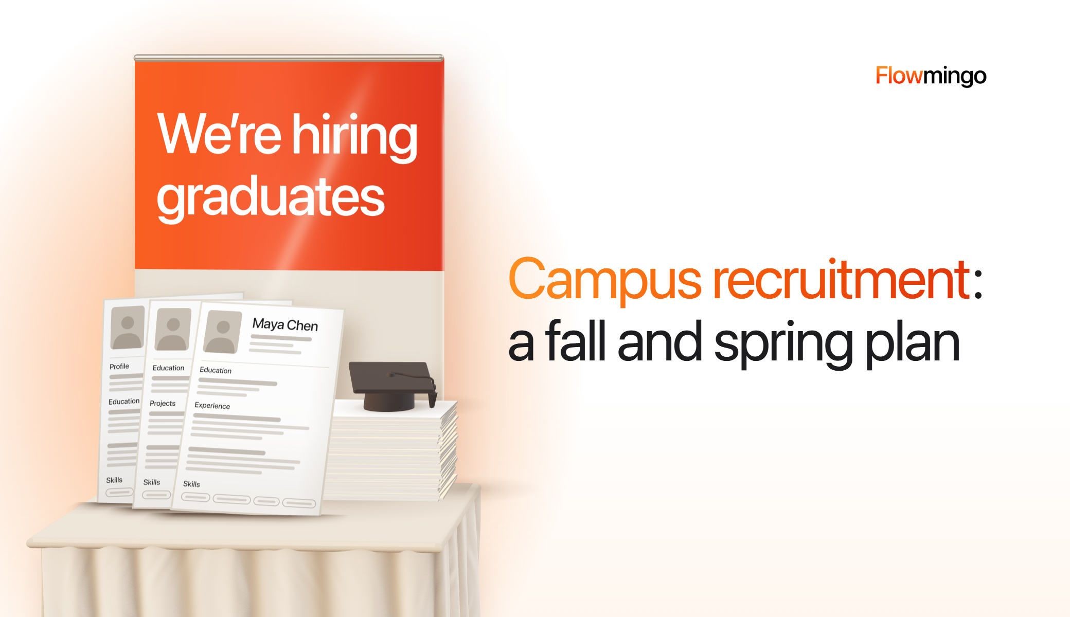 Campus recruitment booth at a university fair: a tall orange pop-up banner reading We're hiring graduates, a table in a cream cloth with 3 printed CVs standing on it, and a pile of CVs topped with a graduation cap